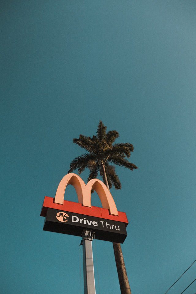 Mcdonalds sign board and a coconut tree behind
